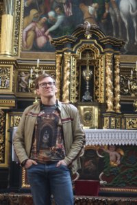 Kacper Pielat przed ołtarzem kościoła Wniebowzięcia NMP i św. Stanisława. Bodzentyn