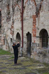 Prof. Łukasz Niesiołowski-Spanó fotografuje detal architektoniczny klasztoru cystersów w Koprzywnicy