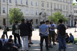 Zasłuchani studenci na tle gmachu Poczty Polskiej w Lublinie