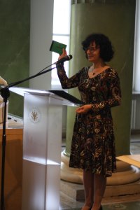 Pani prodziekan za chwilę wręczy symboliczny indeks jednemu ze studentów, który dostał się na studia z bardzo dobrą punktacją.